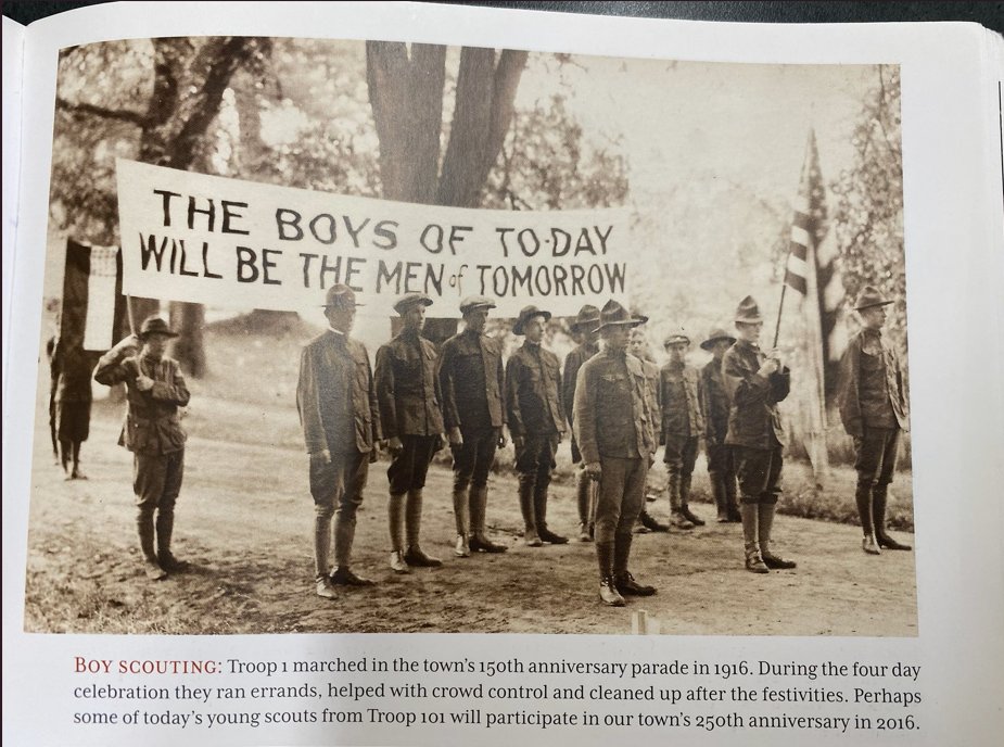 Northborough Boy Scouts marching in the town's 150th-anniversary parade in 1916, behind a banner reading 'The Boys of To-day will be the Men of To-morrow'